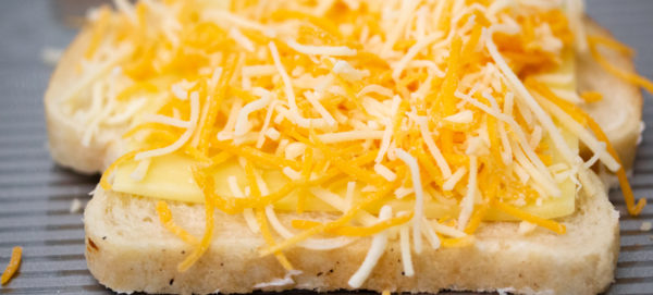 shredded cheese on buttered bread